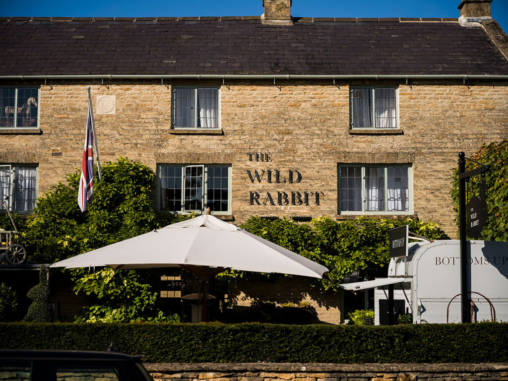 Cotswolds honey stone building with sun shade and outdoor bar. The Wild Rabbit in the Cotswolds